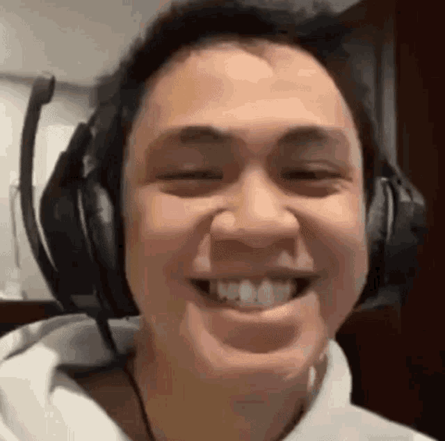 a man wearing headphones is smiling and making a face .
