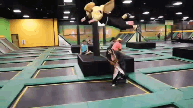 a group of people are playing on a trampoline with a gizmo mascot