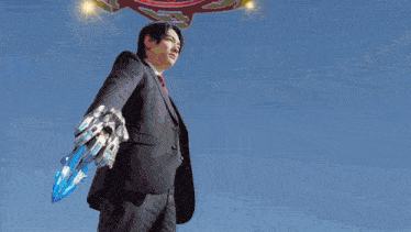 a man in a suit and tie is holding a blue sword
