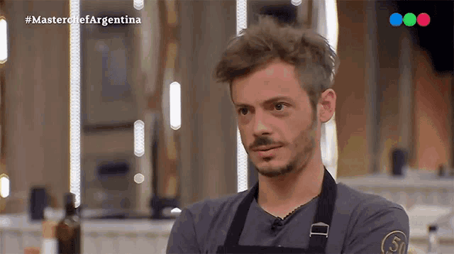 a man wearing an apron is on a television show called masterchef argentina
