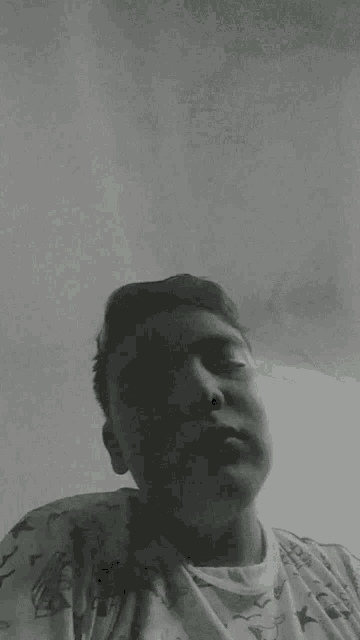 a black and white photo of a young man with his eyes closed .
