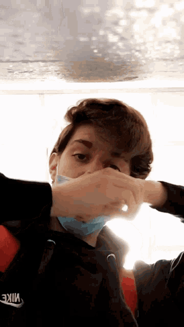 a man wearing a face mask and a nike sweatshirt