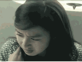 a close up of a woman 's face with a serious look on her face .