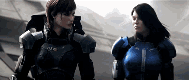 two women in armor with n7 on their chests stand next to each other