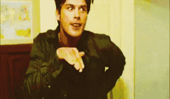 a man in a leather jacket is making a gesture with his hands .