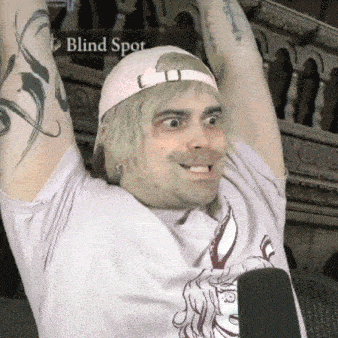 a man wearing a pink hat and a t-shirt that says blind spot on it