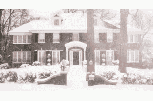 a large brick house is covered in snow and has a red mailbox in front of it .