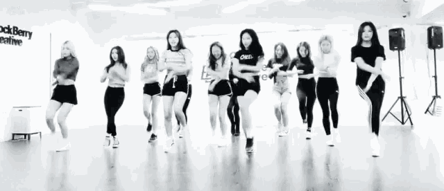 a group of women are dancing in front of a wall that says blackberry creative