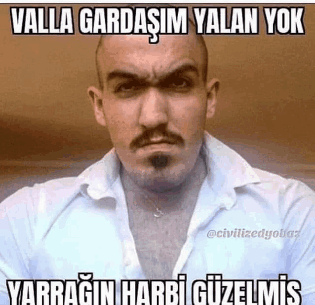 a man with a beard and mustache is wearing a white shirt with a caption that reads valla gardasim yalan yok