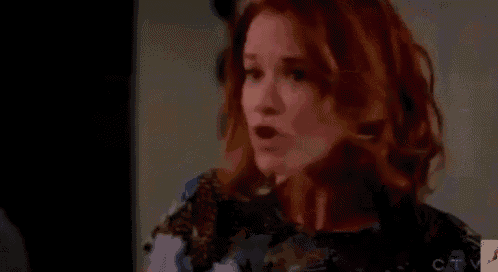 a woman with red hair is crying in a room .