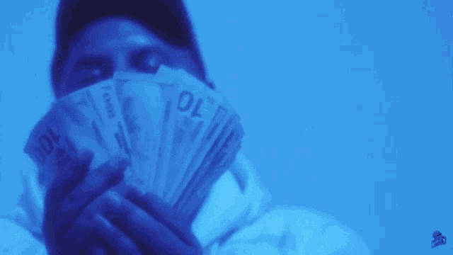 a man is standing in a dark room with a blue light shining on him .