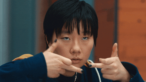 a woman with short black hair is making a funny face with her hands