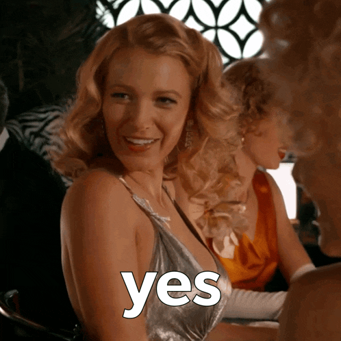 a woman in a silver dress with the word yes written on her chest