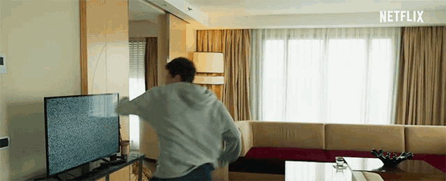 a man in a living room with a netflix logo on the bottom