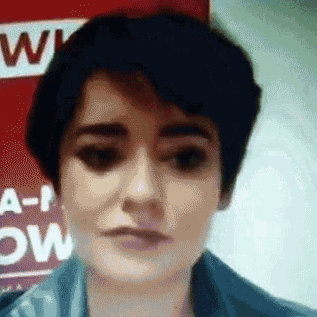 a close up of a woman 's face in front of a sign that says a-now