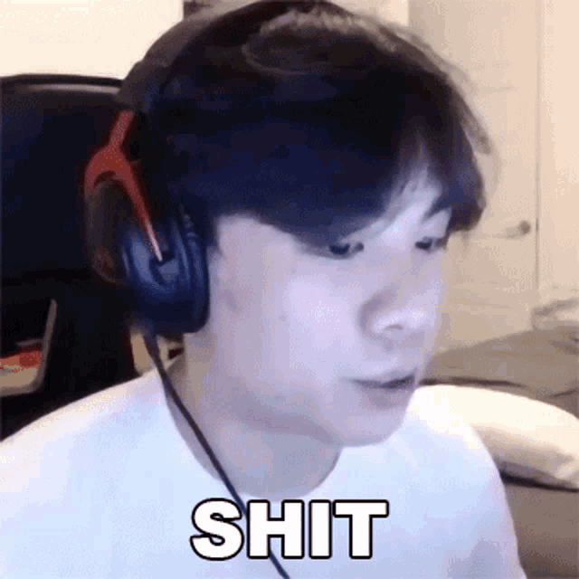 a man wearing headphones and a white shirt is making a funny face and saying shit .