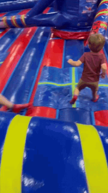 a little boy is playing on a bouncy castle .