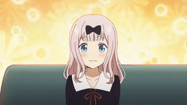a girl with pink hair and blue eyes is sitting on a green couch