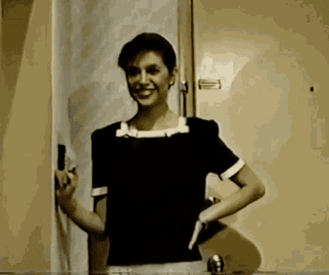 a woman standing in front of a door with the number 1 on the wall behind her