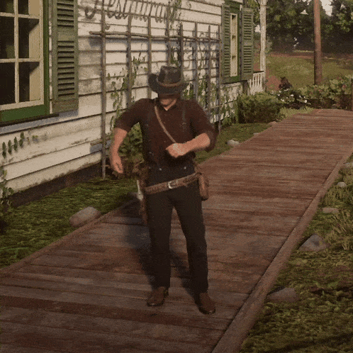a man in a hat is standing on a wooden walkway in front of a house with a sign that says " welcome "