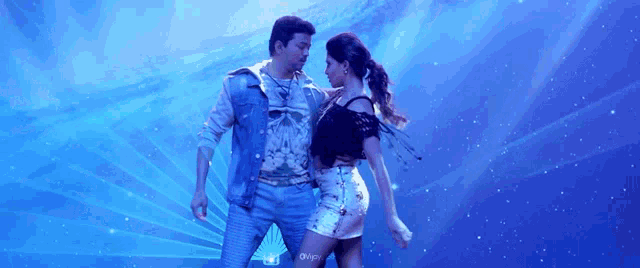 a man and a woman are dancing on a stage with a blue background .