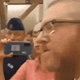 a man wearing glasses is taking a selfie with his phone