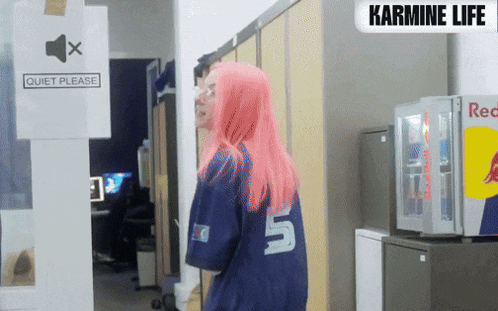 a woman with pink hair wearing a blue shirt with the number 5 on it