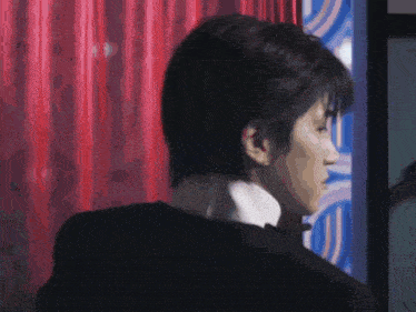 a man in a tuxedo is looking over his shoulder