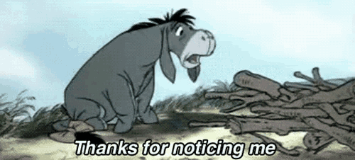 eeyore from winnie the pooh is sitting in front of a pile of logs and says thanks for noticing me .