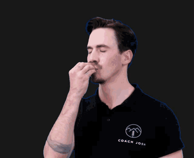 a man wearing a black coach josh shirt