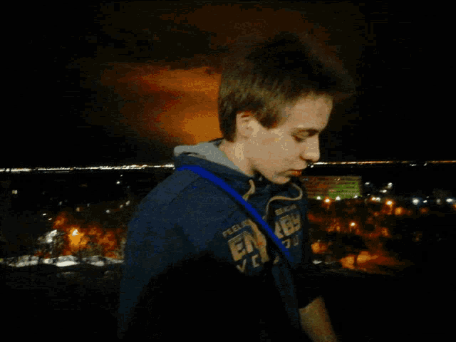 a young man wearing a blue sweatshirt that says ' feelin ' good ' on the front