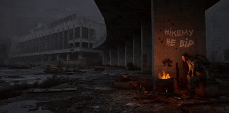 a man is standing in front of a burning barrel with graffiti on it that says " hikomy he bid "
