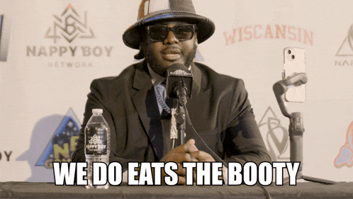 a man speaking into a microphone with the words we do eats the booty on the bottom
