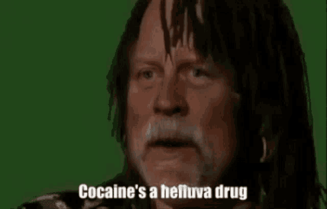 a man with dreadlocks and a beard is talking about cocaine 's a helluva drug .