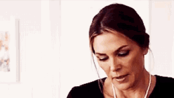 a woman is wearing a black shirt and a necklace .