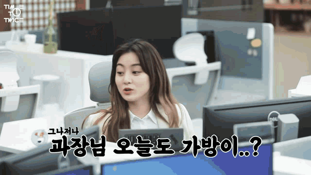 a woman sitting in front of a computer with twice written above her