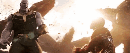 thanos and iron man are fighting each other in a movie scene from avengers infinity war .