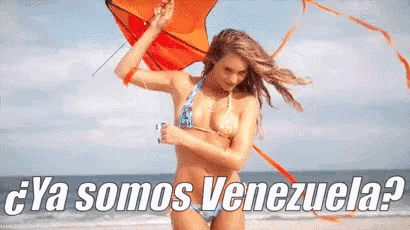 a woman in a bikini is flying a kite on the beach with the words ya somos venezuela