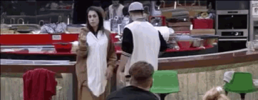 a man and a woman are standing in a restaurant .