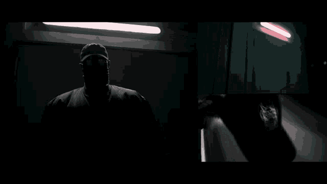 a black and white photo of a man in a dark room
