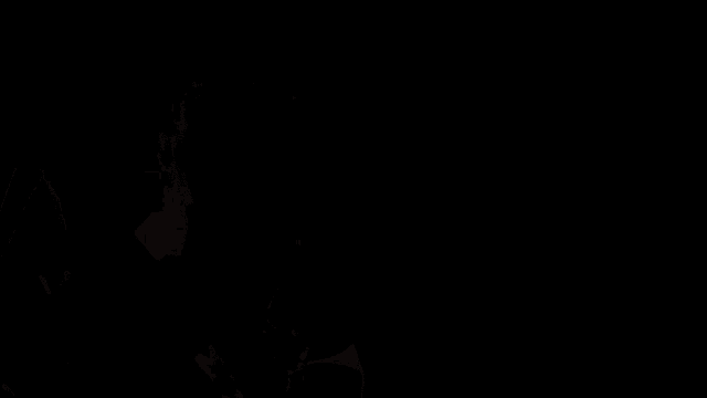 a man wearing headphones is sitting in front of a microphone in a dark room