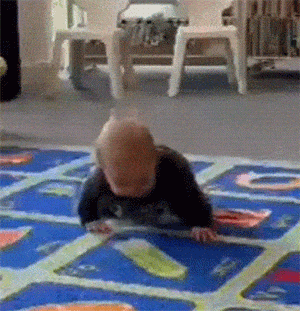 a baby is crawling on a blue rug with letters a and b on it