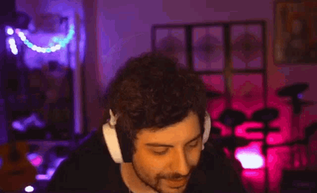 a man wearing headphones is making a funny face in front of a drum set