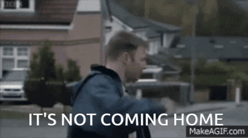a man walking down a street with the words " it 's not coming home "