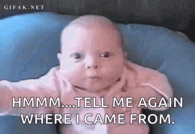 a baby is laying on a blue pillow and making a funny face .