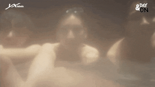 a group of people are sitting in a hot tub with a day & on logo in the background