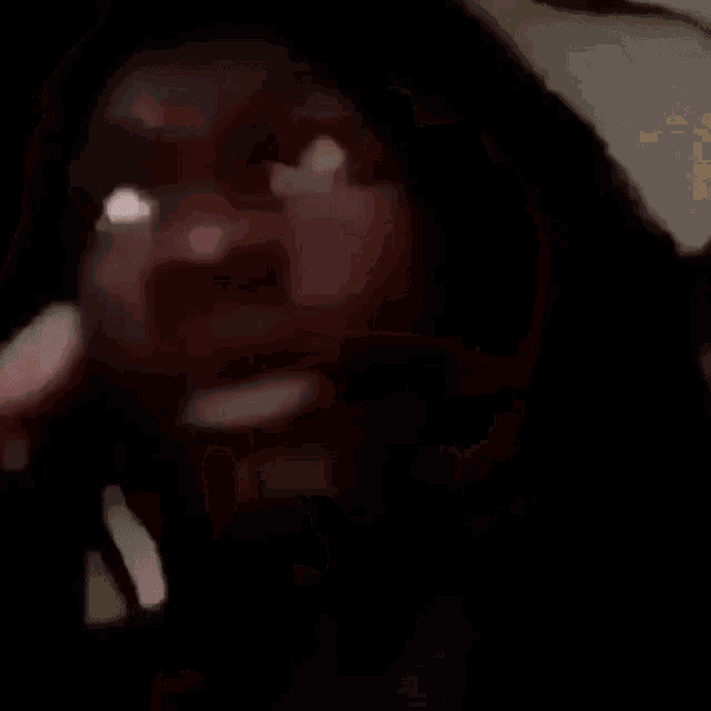 a person is holding a cigarette in their hand and smoking it .