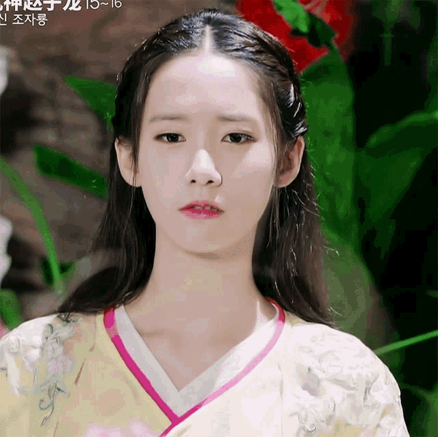 a woman in a yellow and pink kimono with flowers on it