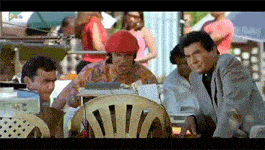 a man in a red hat sits at a table with two other men and a sign that says pan