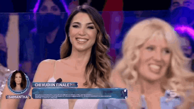 a woman in a white dress is smiling in front of a sign that says chi vuoi in finale